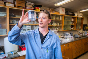 male student holding up speciman