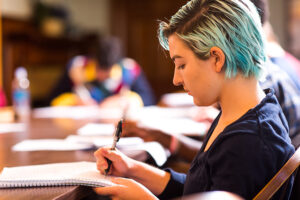 female student writing in notebook