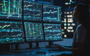 student looking at computer screens with analytics on them