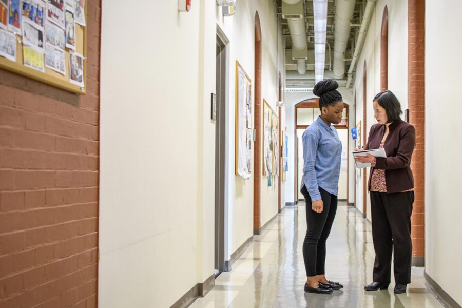 undergraduate student with professor in hall way