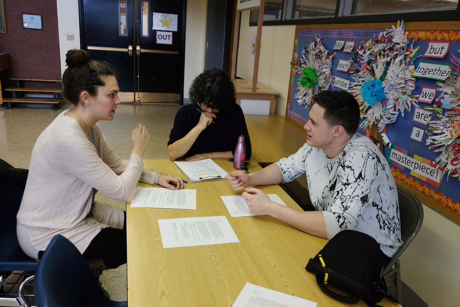 teacher at desk with high school student