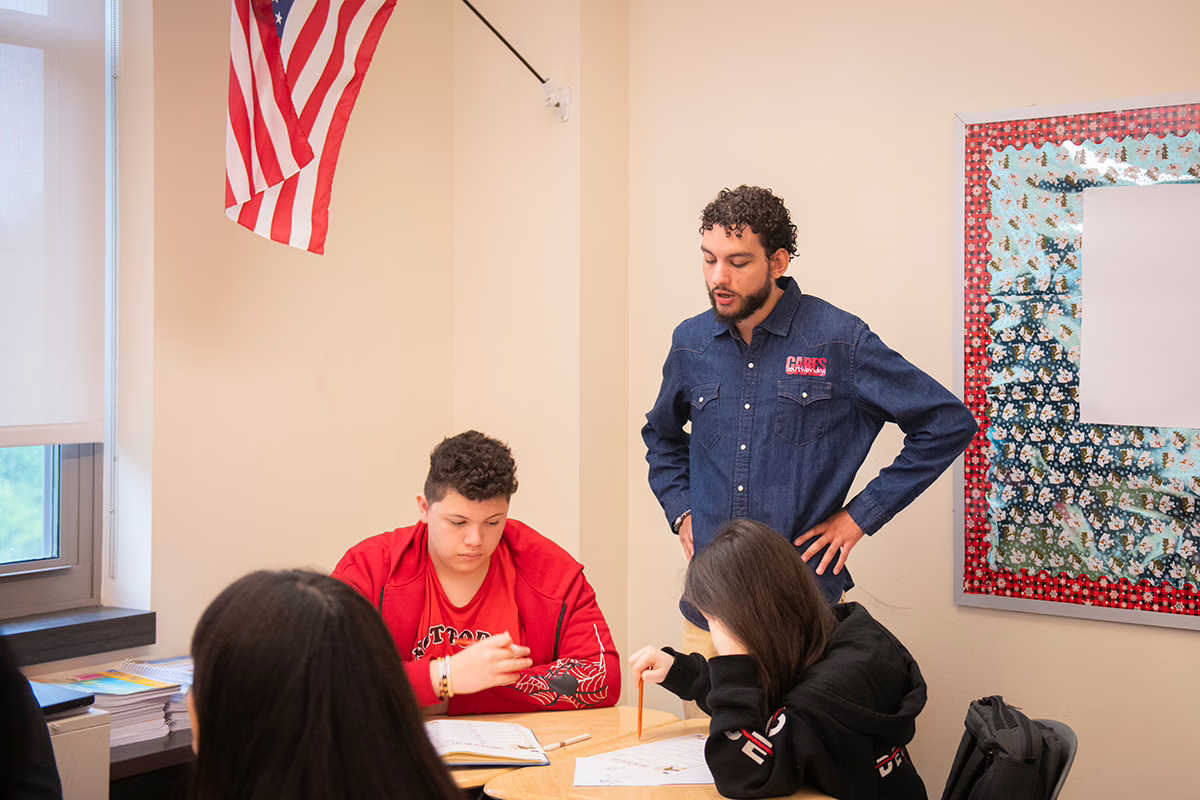 mentor showing student how to do something on paper