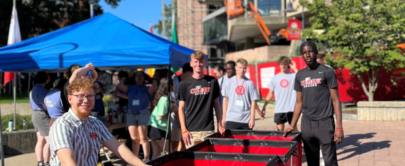 Students with moving bins in front of the Library at Clark University