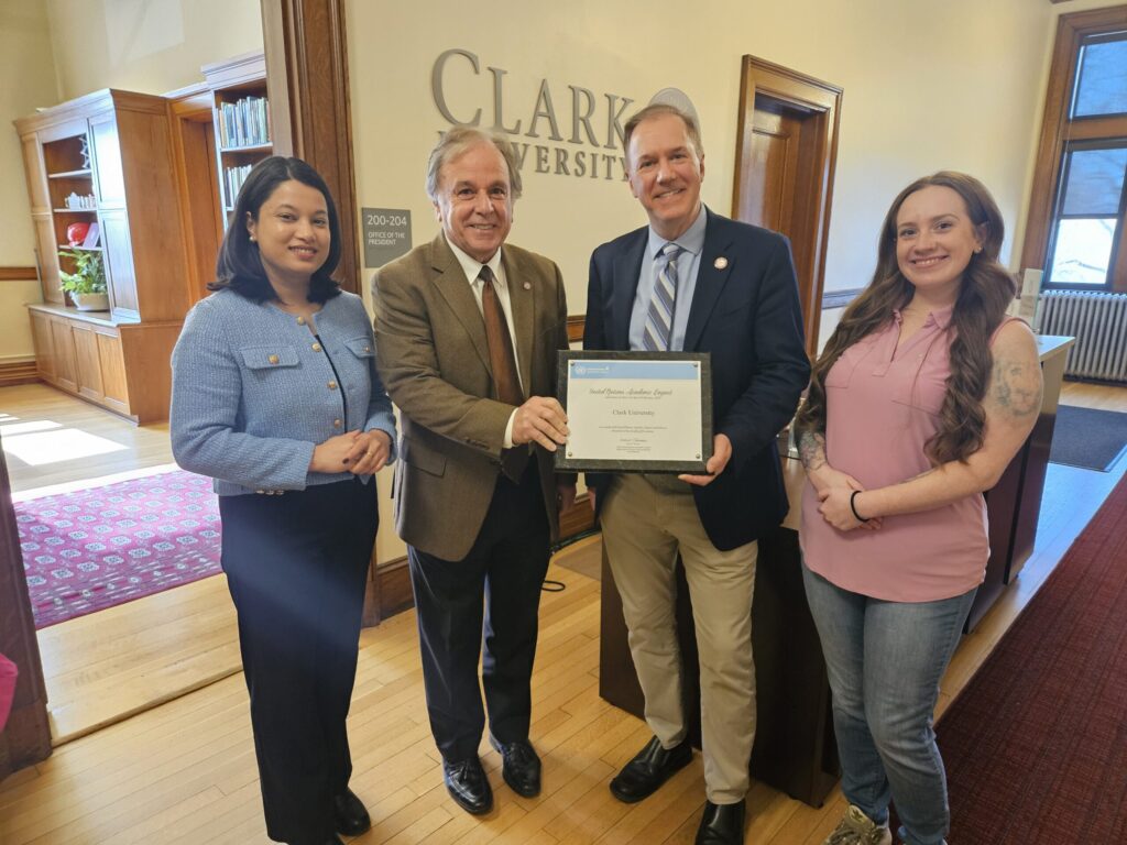 Current MBA student Rakshya Bhandari; School of Business Dean, David Jordan; Clark University President David Fithian; Former MBA student, Amanda Edson, with the official certificate from the United Nations