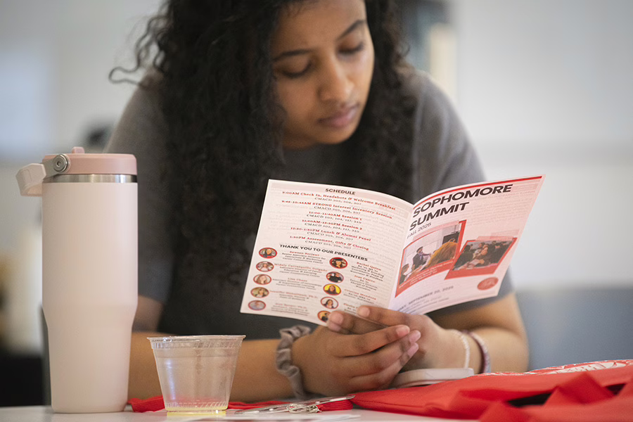 female student looking over pamphlet