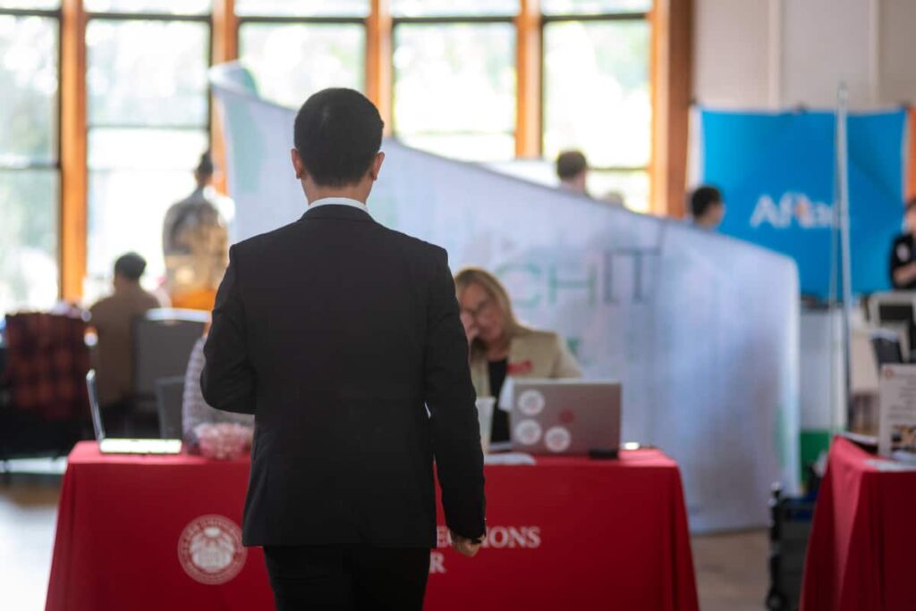 a student approaches a table during the Fall Career Fair
