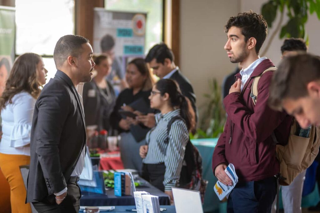a student and emplyer interact at a career fair