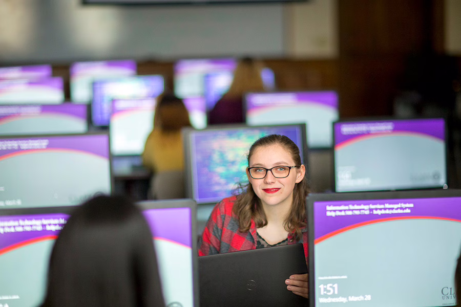 girl sitting behind computers with intranet on