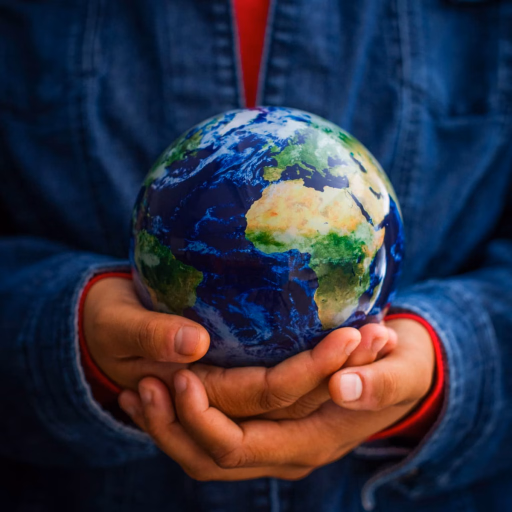 a student cups the globe in her hands