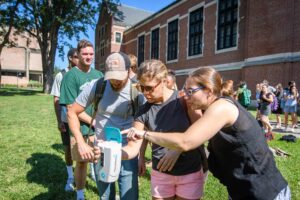 Florentia Sangermano works with a class outdoors with a remote sensing device.