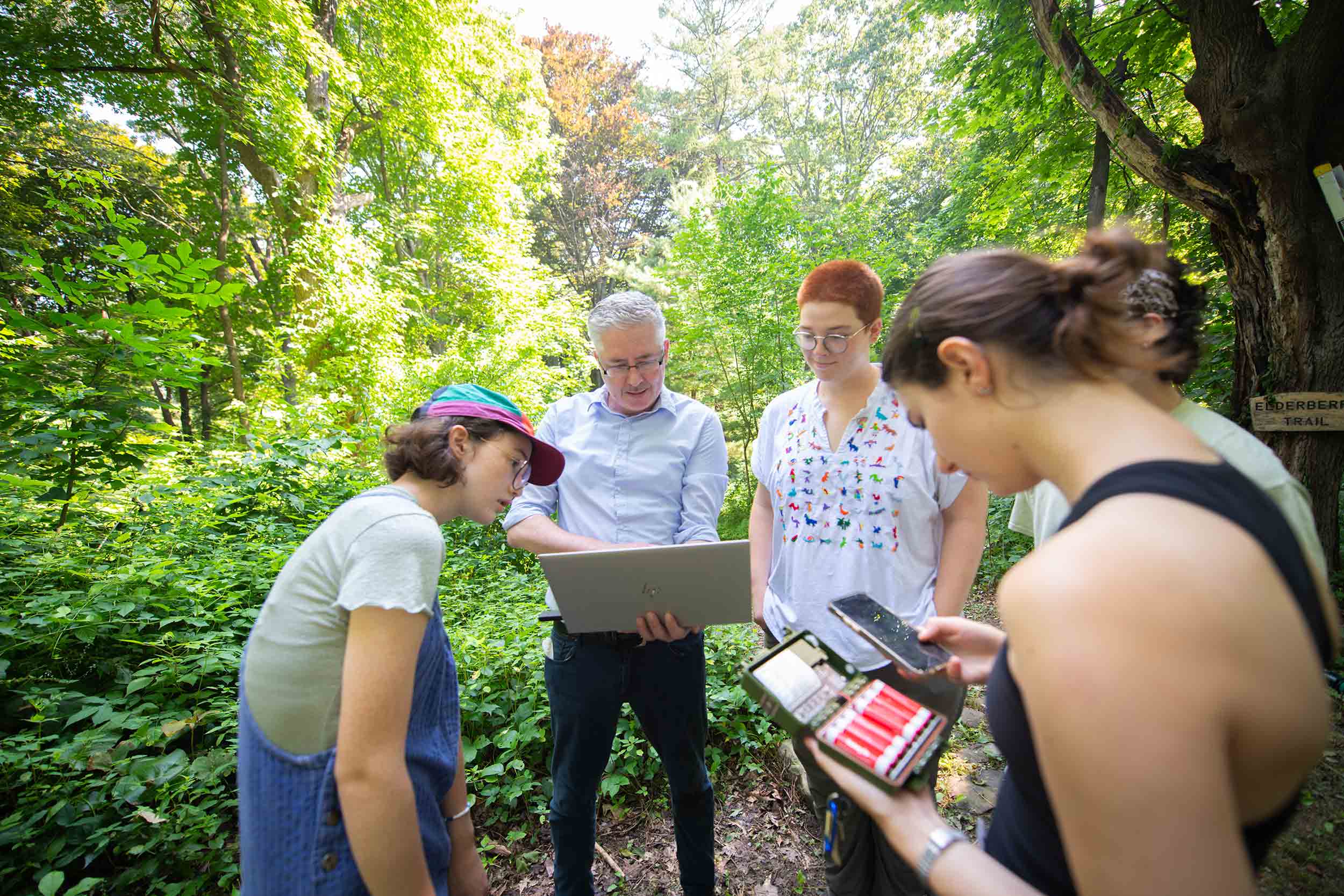 A group of students work with a faculty member on obtaining bat sensing data in Hadwen Arboretum