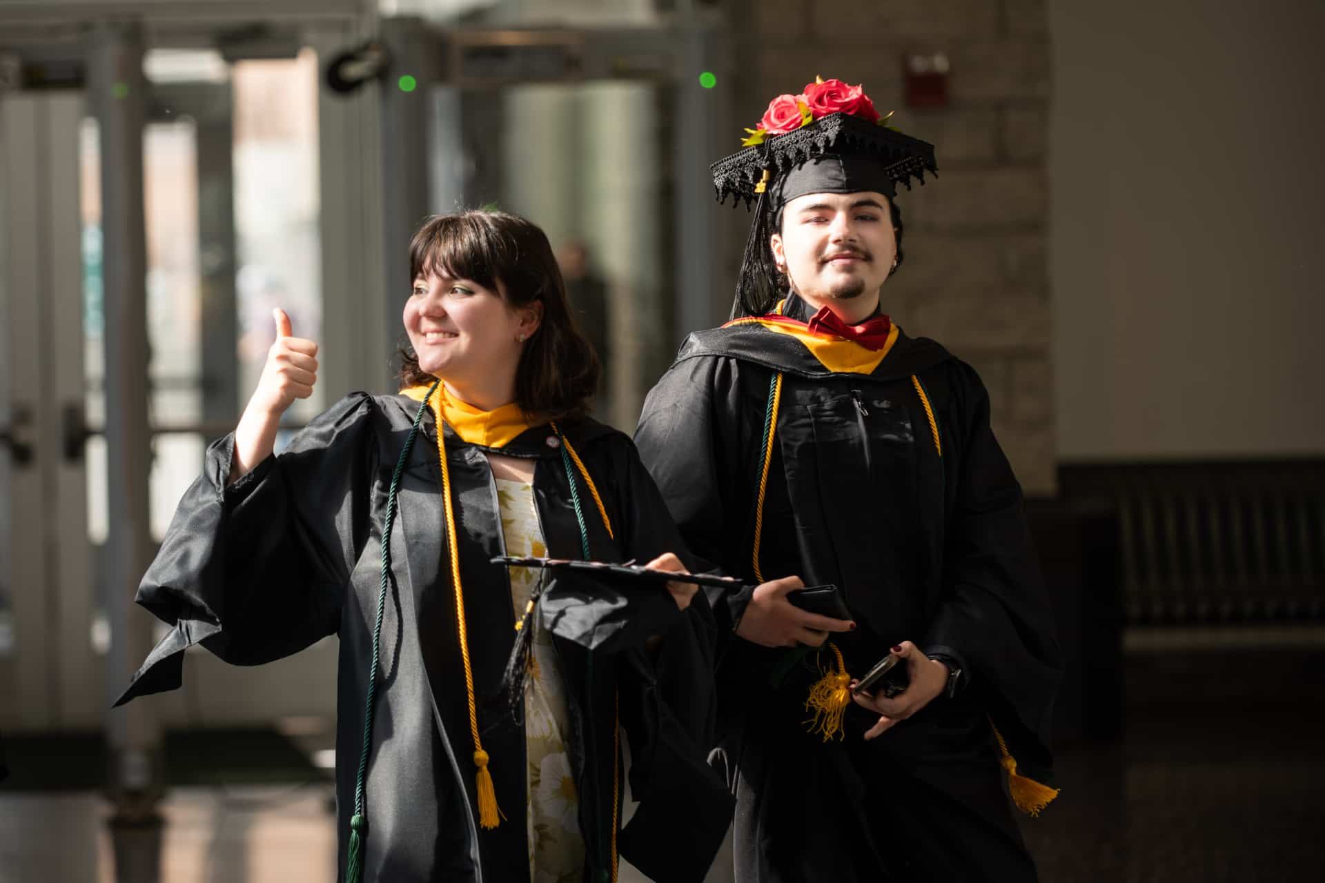 students give a thumbs up as they prepare for commencement