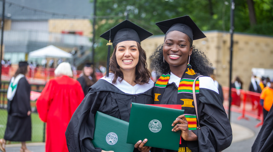 Two students posing with cap and go