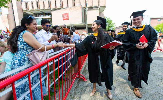 graduate student shaking hands with family at graduation