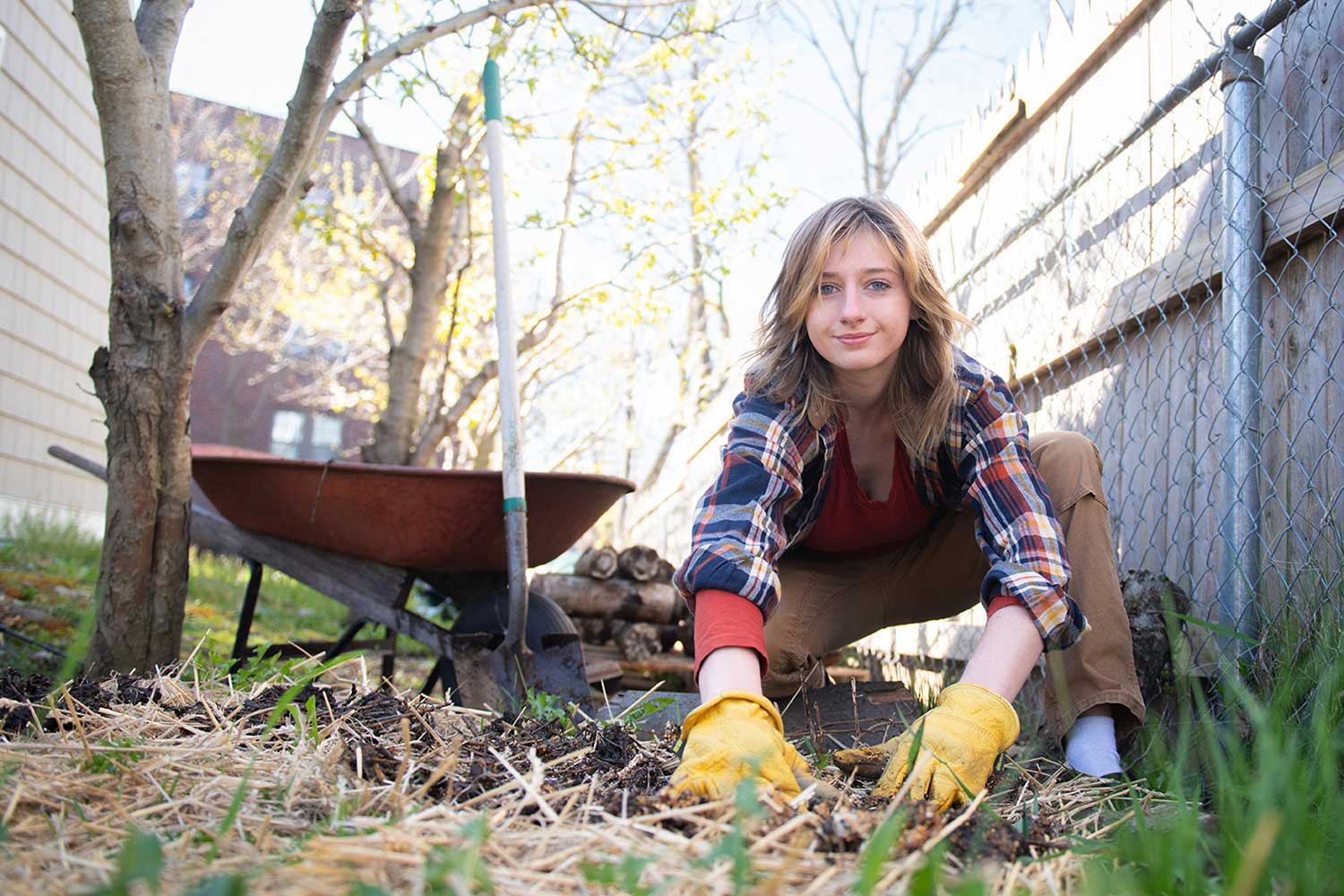 Amanda Dye ’24 working in a garden bed at Worcester Common Ground’s Jacques Ave. Bioshelter, a nonprofit that promotes locally sourced food