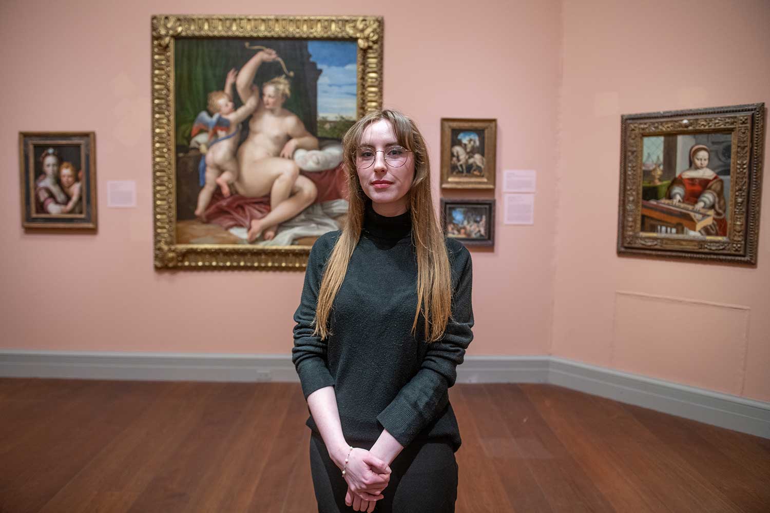 Emily Abney standing in front of a painting of Venus and Cupic in the Worcester Art Museum