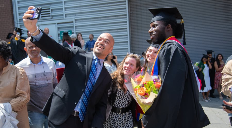 A parent shoots a selfie with graduates