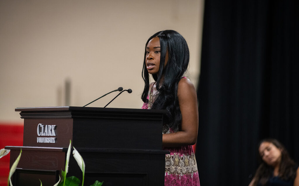 girl speaking at podium in Fiat Lux Honor Society