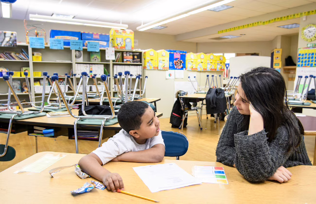 graduate student in classroom with pre-k student