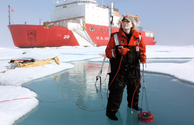 Karen Frey in front of coast guard vessel in artic