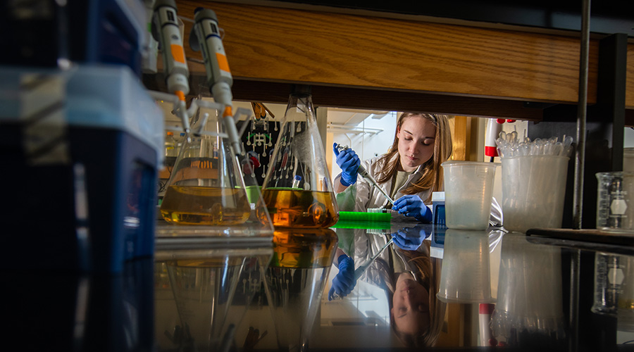 chemistry student in chemistry lab taking samples