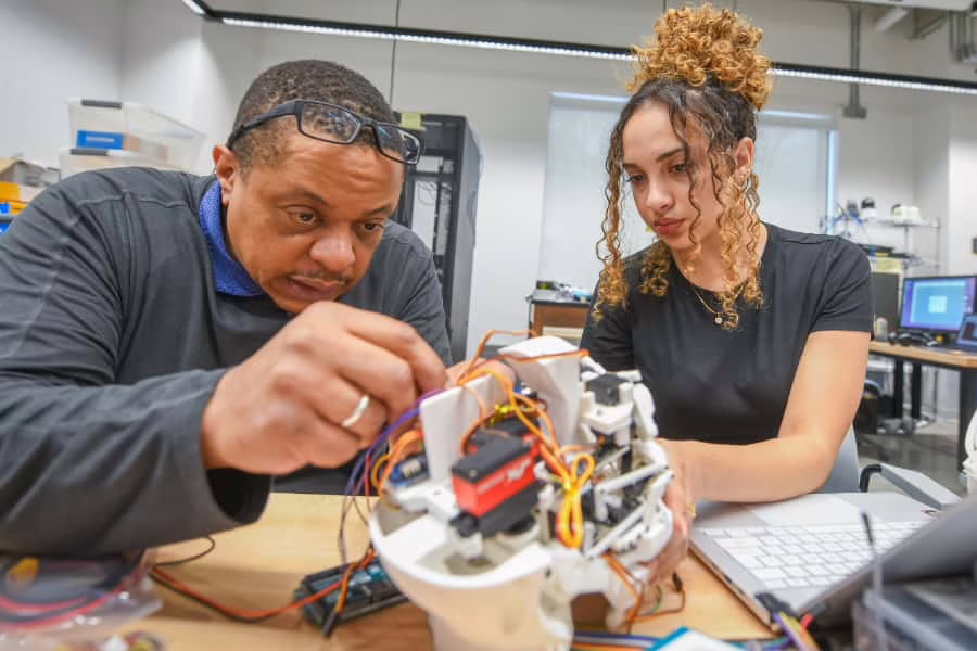 Gary Holness works with a student on a robotics project