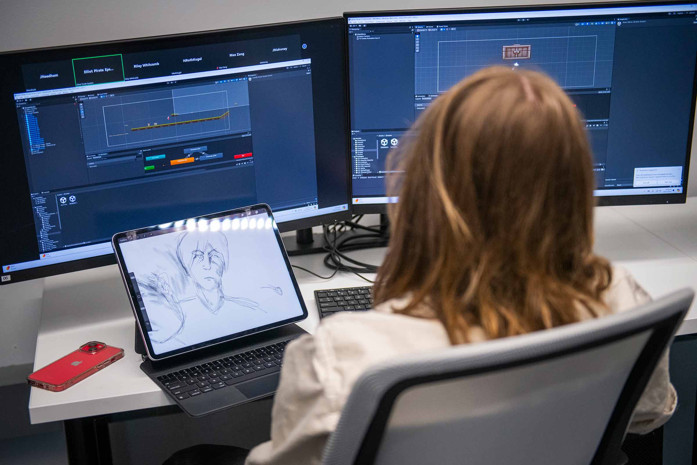 Student working with a drawing on a tablet and two monitors.