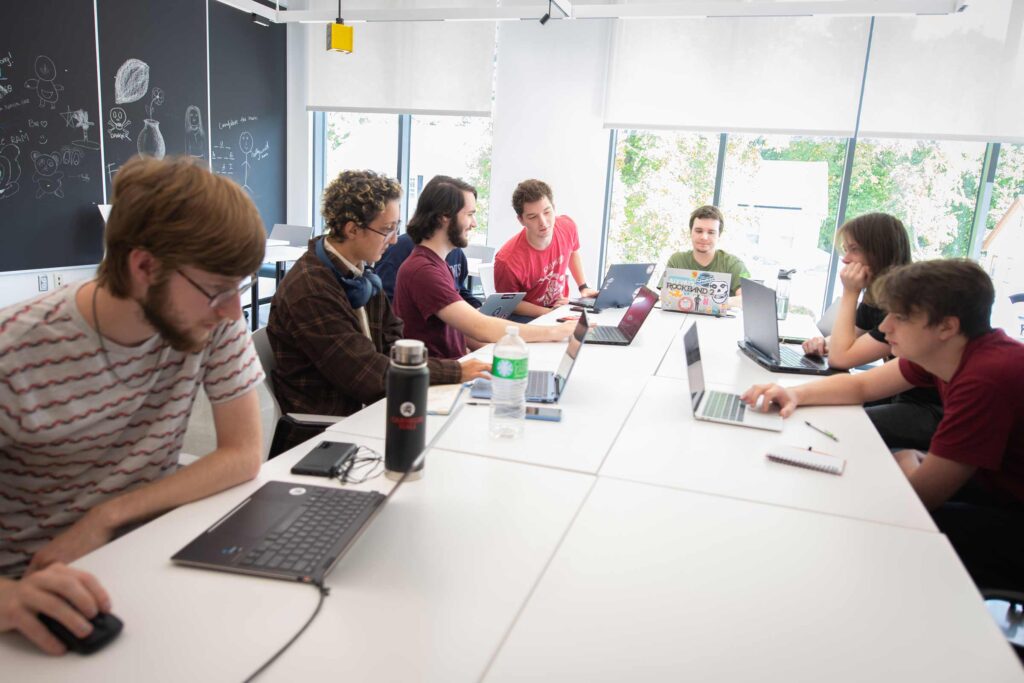 Students discussing a project in a game design studio meeting