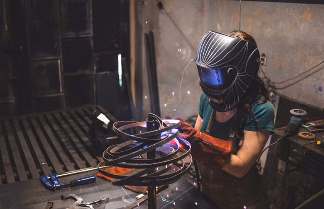 a student welds a sculpture