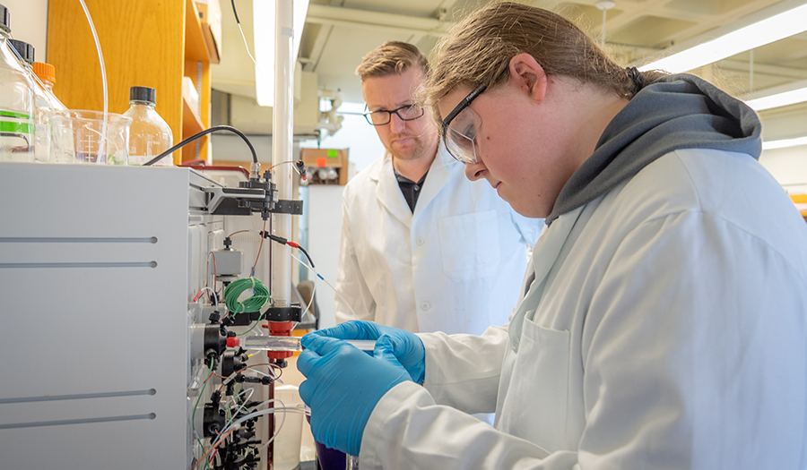 student working in lab with faculty member overseeing