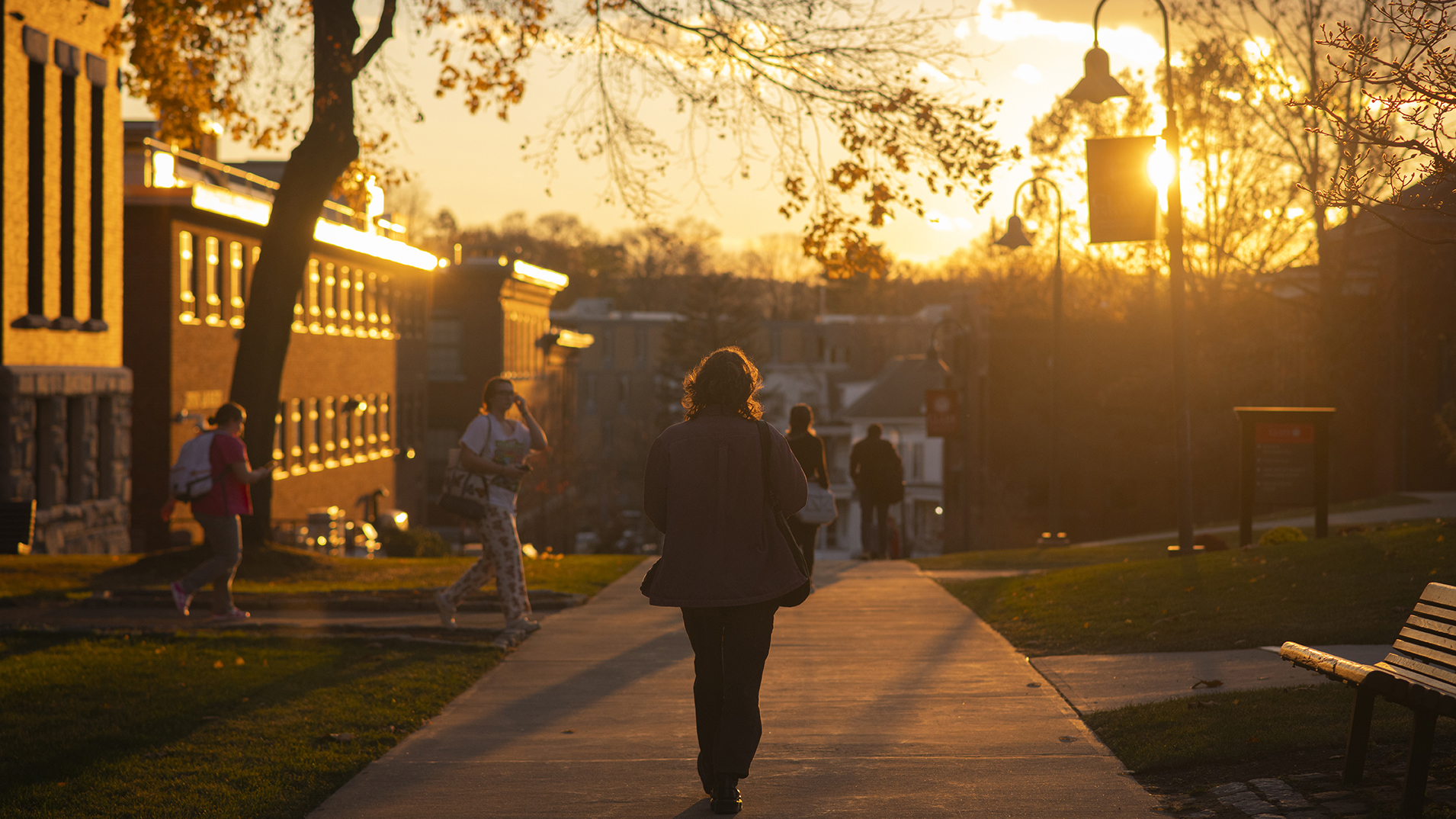 Clark University student walking on campus at sunset