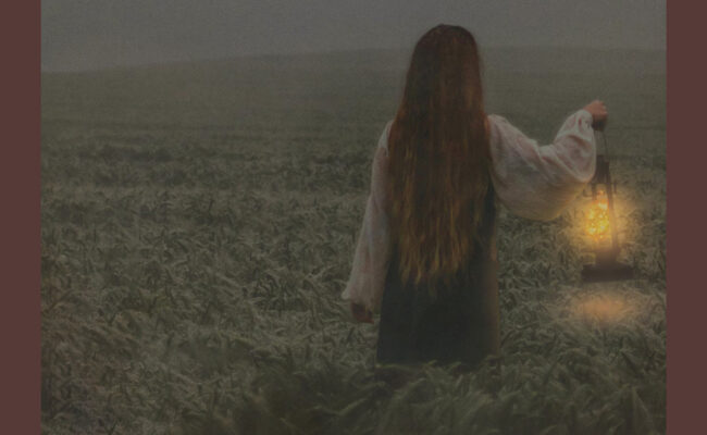 Girl in a field holding a lantern