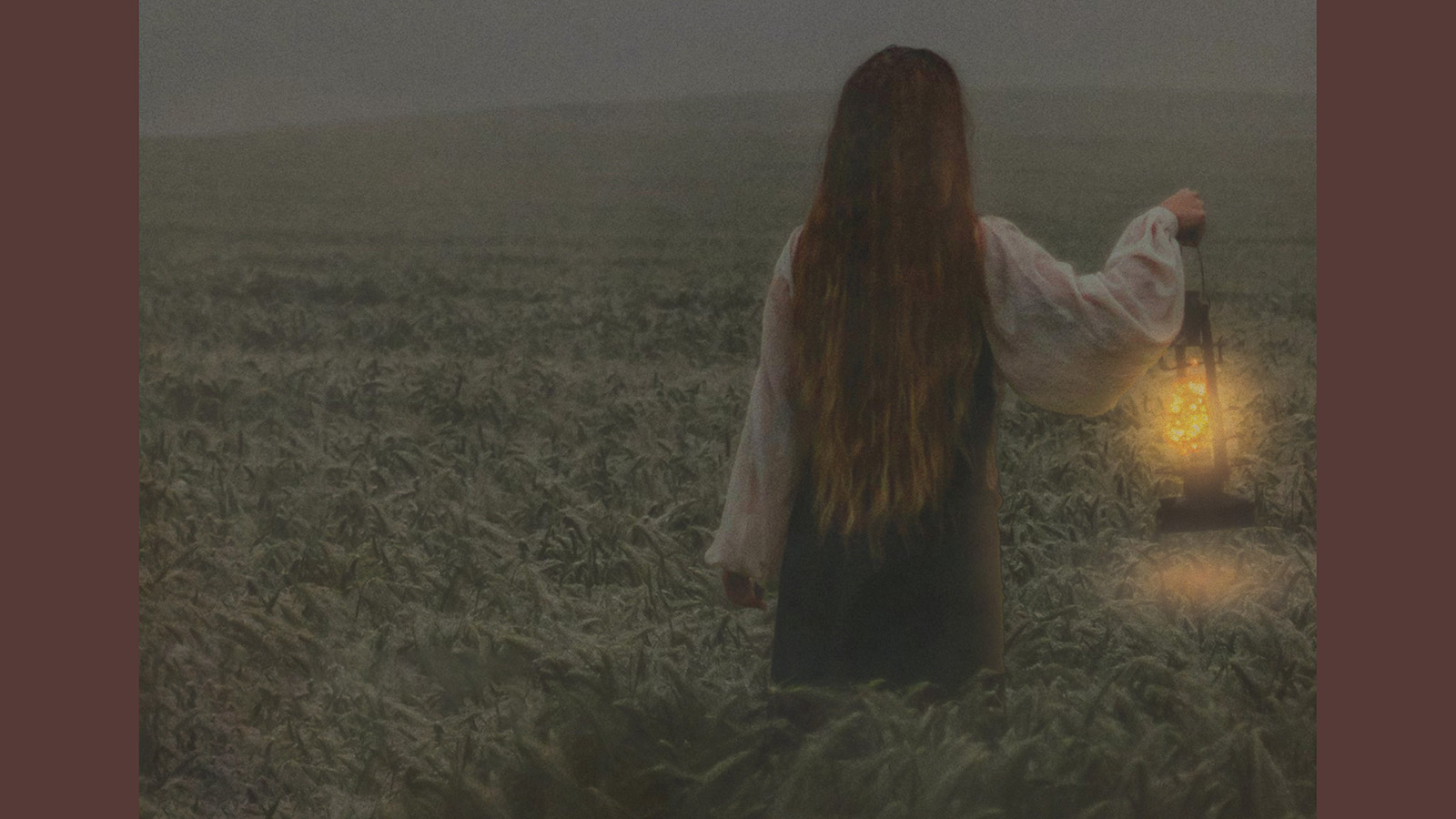 Girl in a field holding a lantern