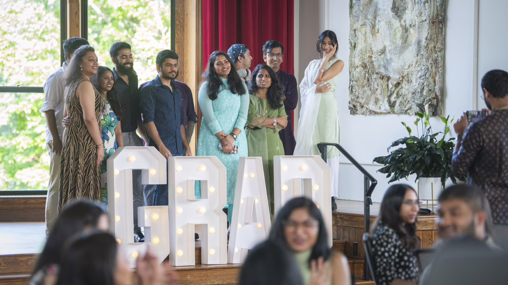 International students pose with GRAD sign at 2025 graduation event