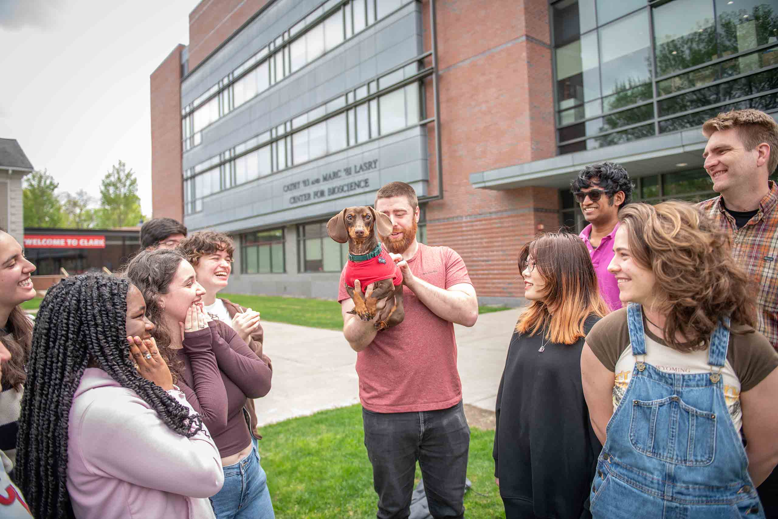A group shot, including the canine mascot of the Nathan Ahlgren lab group, outside
