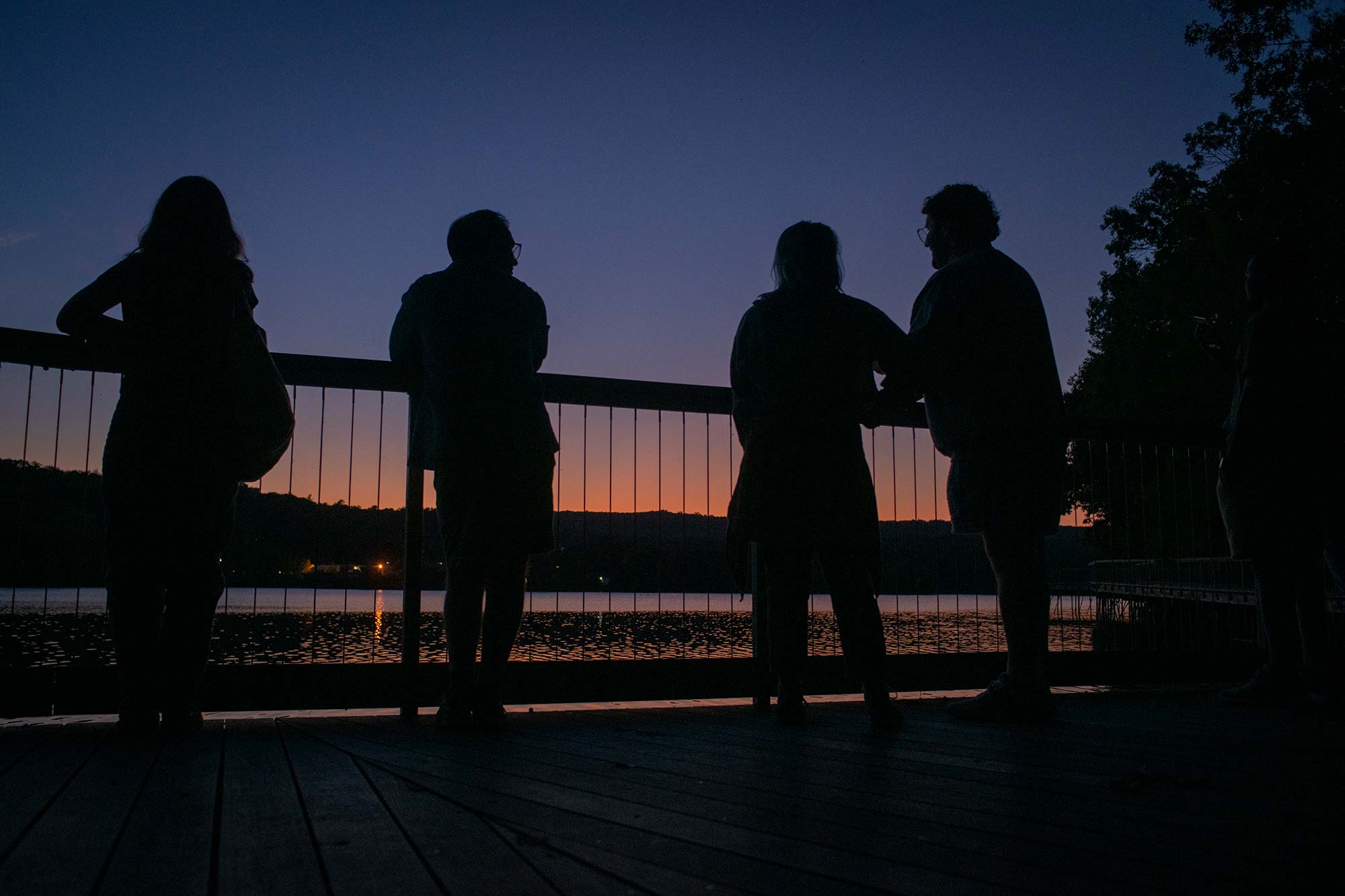 Student silhouettes against the sunset at Coes Pond, Worcester