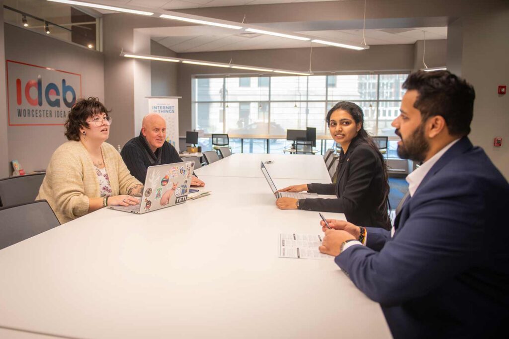 School of Business students Parimala Yerraguntla, M.S. ’25, and Aaryan Pankaj Dabhade, M.A. ’25 (right), meet at the Worcester Idea Lab with Margie Breault, business and community advancement manager for the City of Worcester Office of Economic Development, and Tom Herald, director of the Small Business Development Center at Clark University.