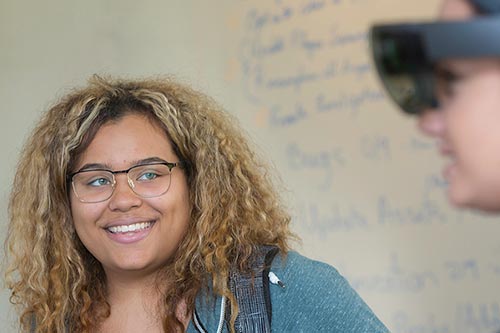 A smiling student in an interactive media and game design class