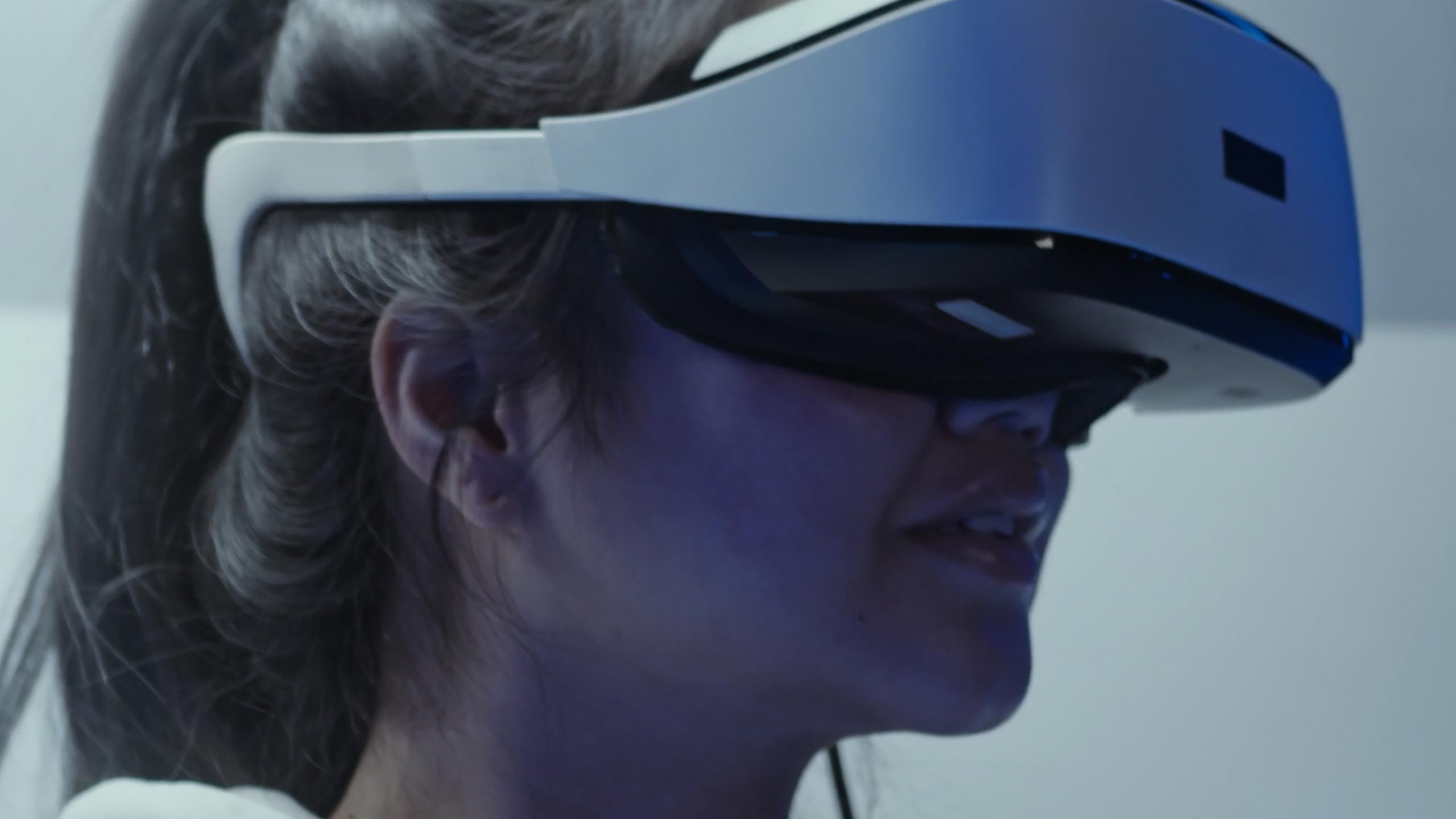 A still image student wearing vr goggles. The video shows a class where students and a professor work on a 3d model of a bee with a closeup of the animated final product and a screen grab from a game designed by students in the Becker School.