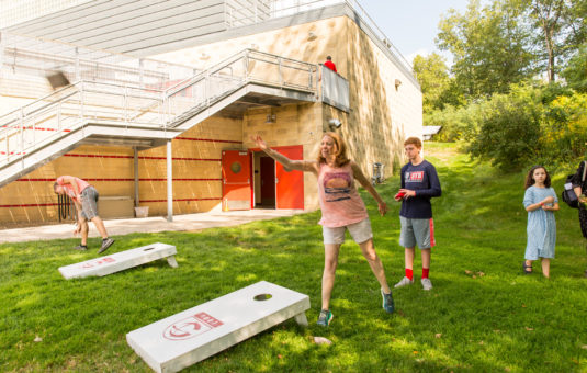 family playing corn hole board game