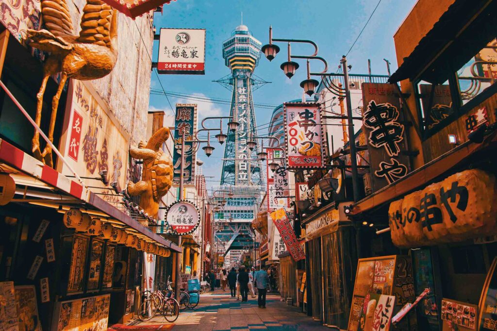 Street view with many signs and a sculpture of a turtle, Osaka, Japan. Photo credit: Nomadic Julien on Unsplash
      