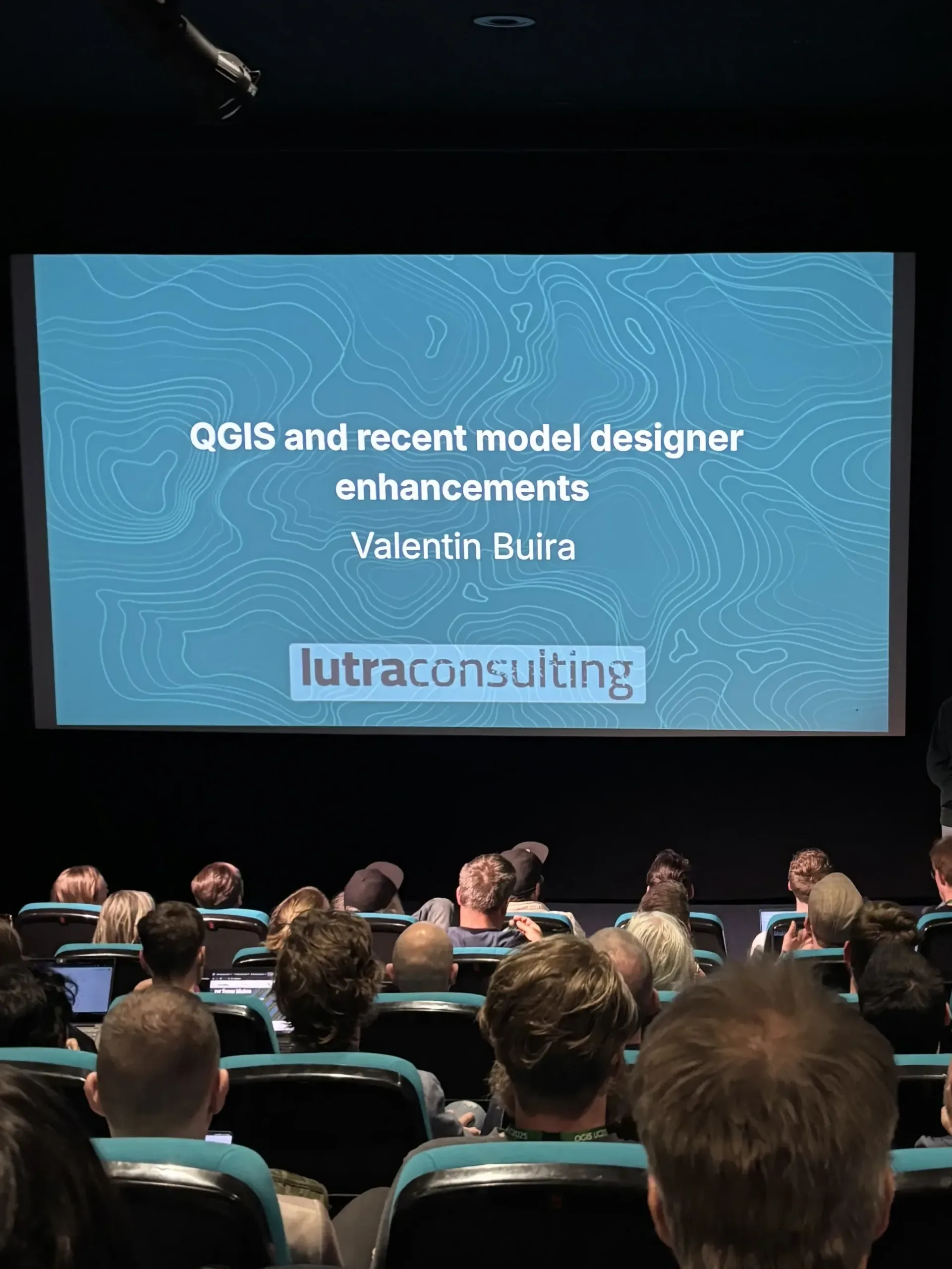 A title slide for "QGIS and recent model designer enhancements" by Valentin Buira.