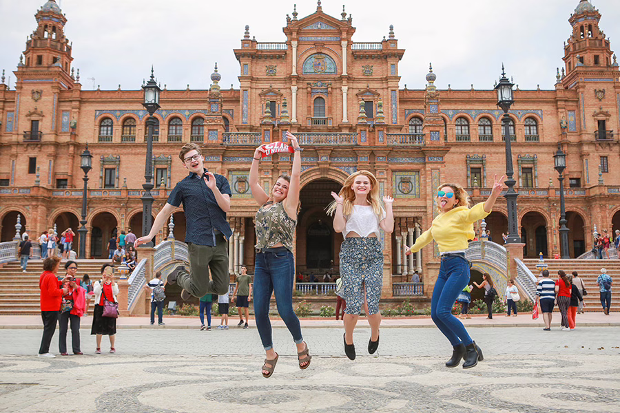 students jumping up in the air in front of a museaum