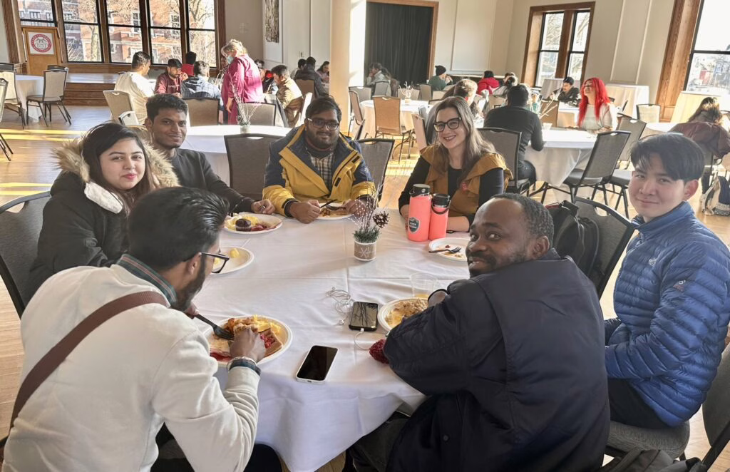 international students sitting at table eating