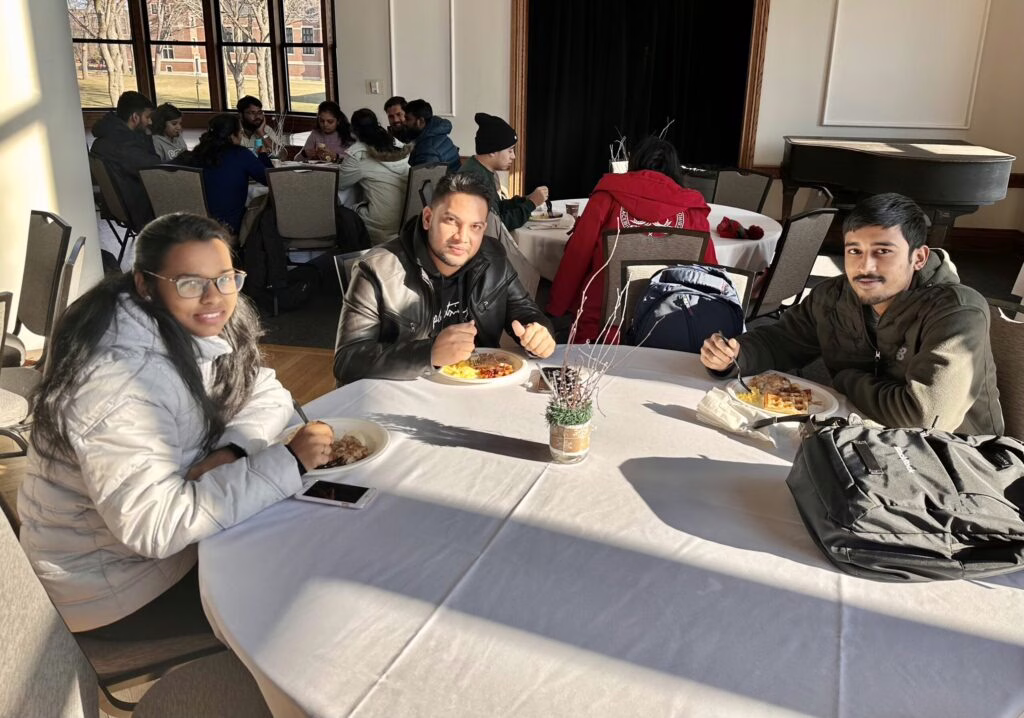 international students sitting at table eating breakfast