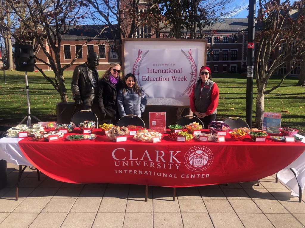 students behind table for international center with food on it displayed