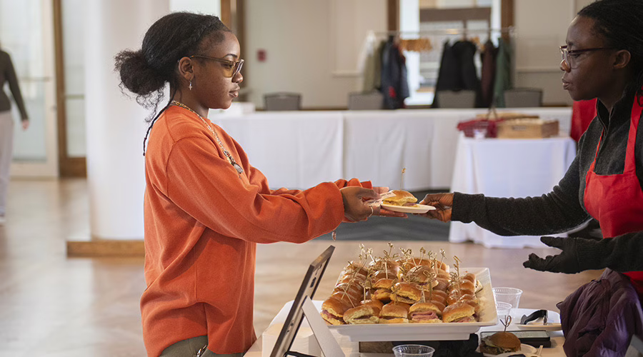 Taste of the world - student handing out mini slider hamburgers