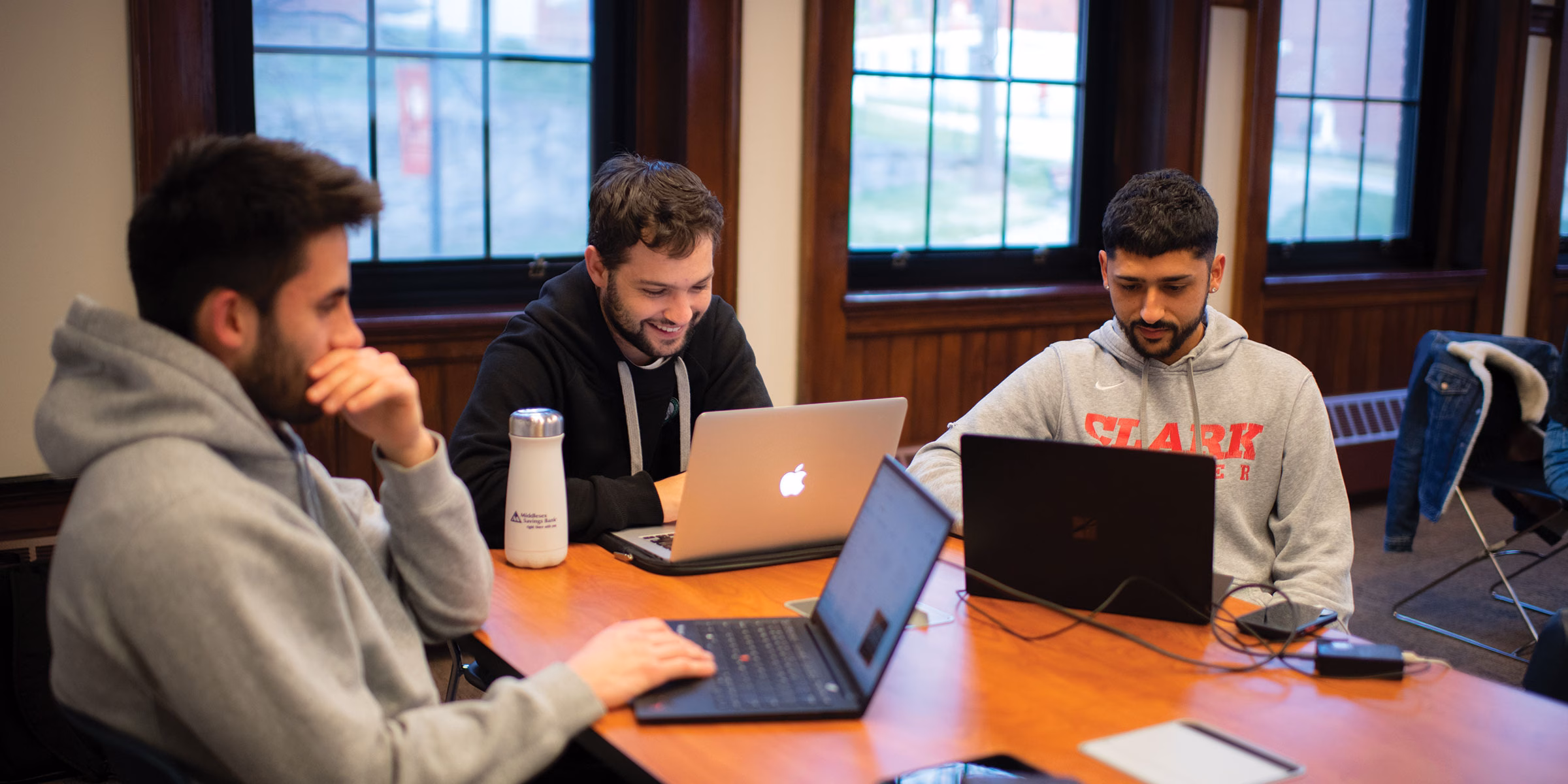 three graduate students talking in classroom