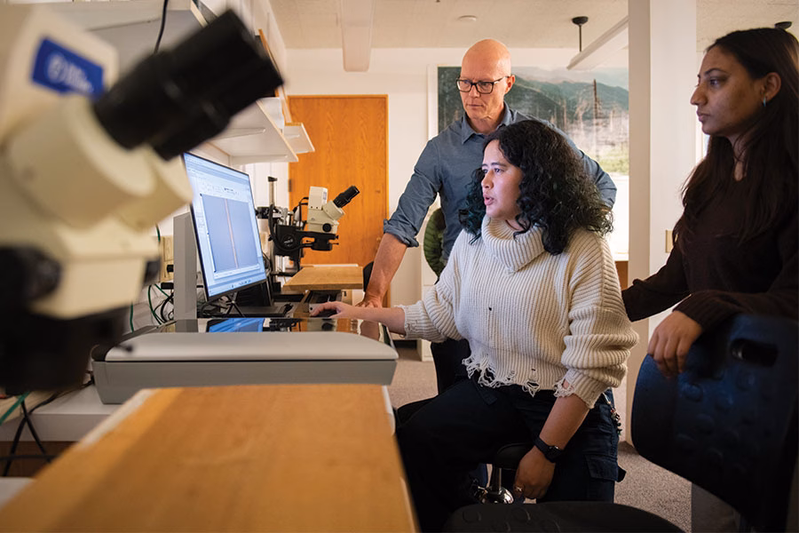 Students using microscope and computer to analyze tree rings
