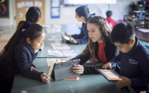 young female teacher with elementary students in a classroom setting